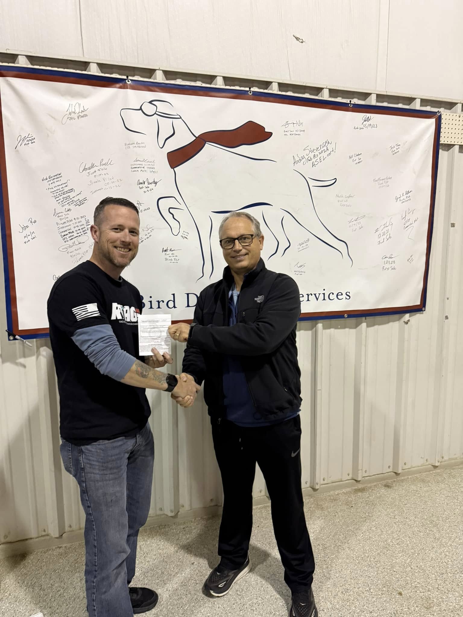 Student pilot signing the checkride wall of fame at Bird Dog Flight Services at Hicks Airfield