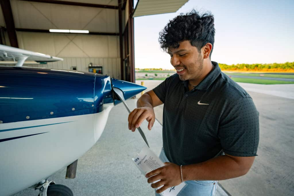 Student pilot and flight instructor conducting pre-flight inspection at Hicks Airfield